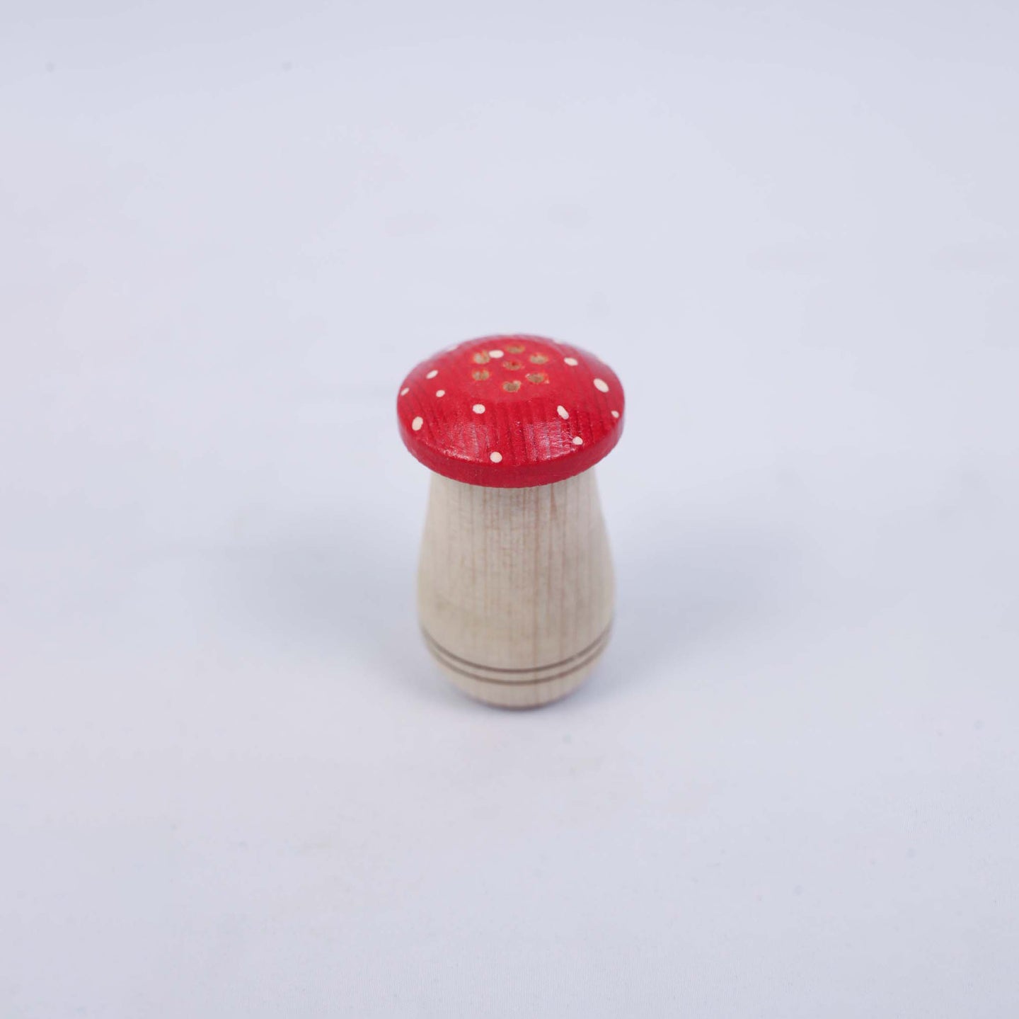 Small Salt Shaker With a Red Cap In The Shape Of a Mushroom